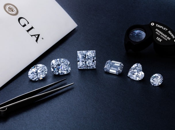 Assortment of Polished Diamonds in Different Cuts With a GIA Report Document